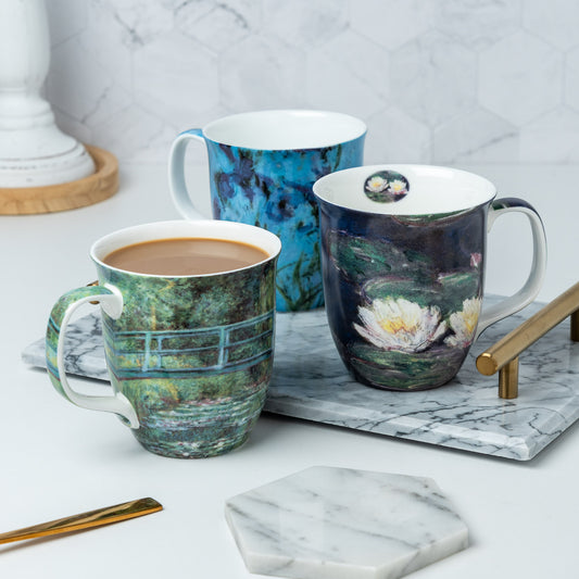 A set of three bone china mugs, each with the art of Claude Monet in prints Water Lilies, The Japanese Bridge, and Lilac Irises.