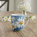 Mug with daisy design against a sky blue base on a wooden table with flowers in the background
